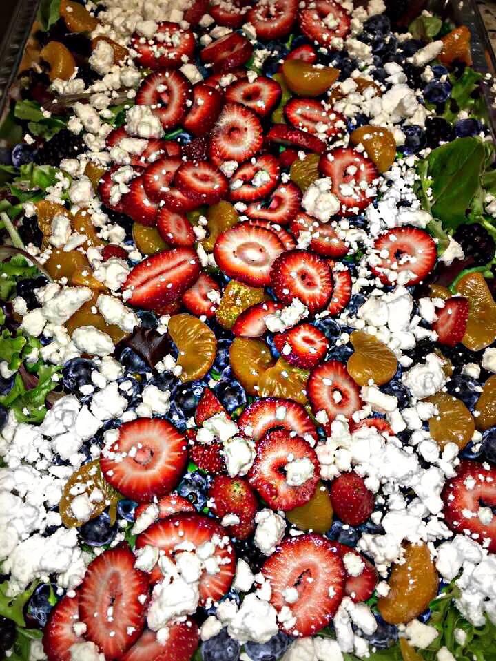 Mixed greens salad with strawberries, blueberries, mandarin oranges, and goat cheese